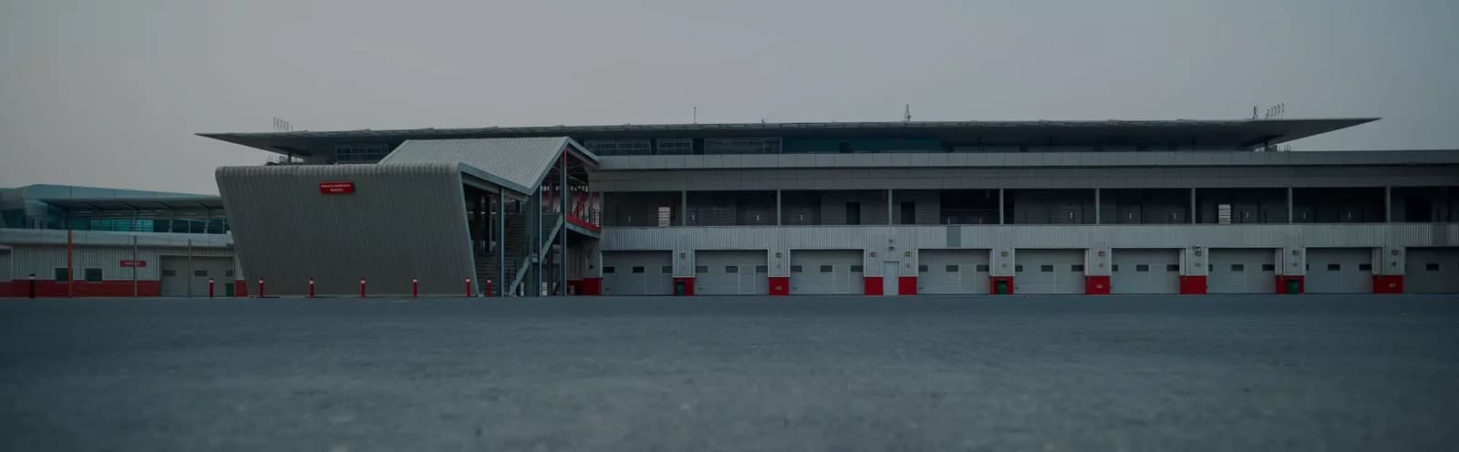 A race car on the Dubai Autodrome circuit at dusk