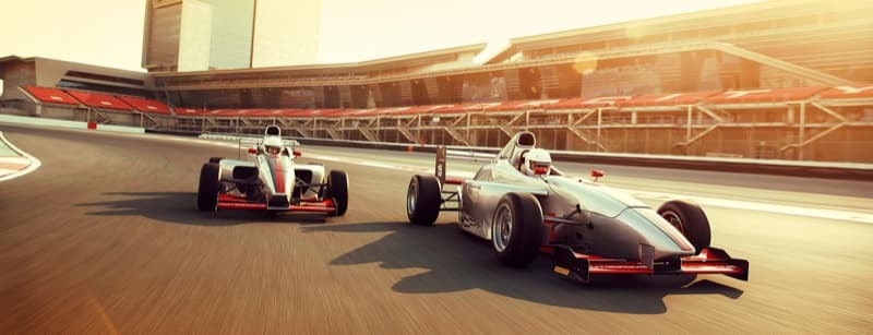 Two single-seater race cars on the main straight at Dubai Autodrome